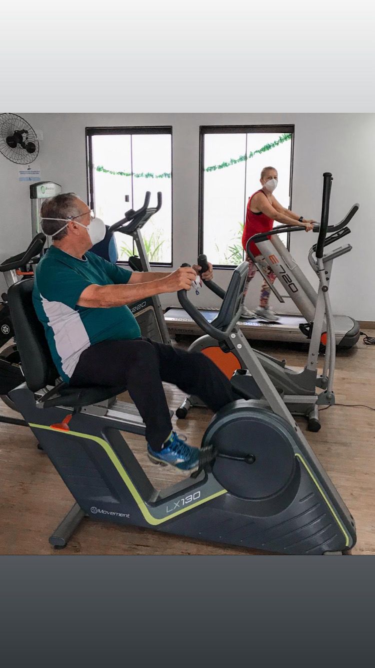 Paciente em treino aeróbico na bicicleta reclinada durante a reabilitação